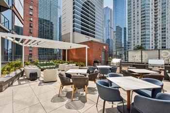 a rooftop patio with tables and chairs and skyscrapers in the background  at Cassidy on Canal, Illinois, 60606